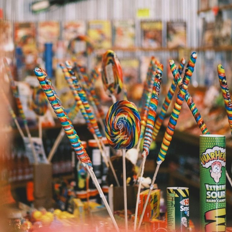 Bonbons Bondues Des bonbons colorés en vrac, incluant des sucettes en spirale et des bâtons arc-en-ciel.